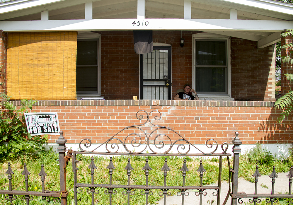 Nathan Stickel sits on his porch in Globeville with a sign planted in his yard reading "My community is not for sale." (Kevin J. Beaty/Denverite)
globeville; denver; denverite; kevinjbeaty; colorado; gentrification;