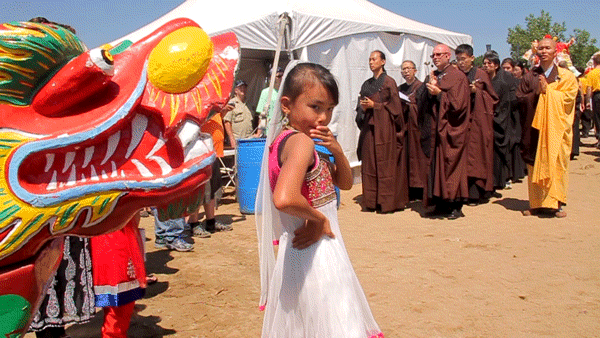 Zen Buddhists stand at the edge of Sloan's Lake during a ceremony to dot dragon boats' eyes, bringing them to life for the Colorado Dragon Boat Festival. (Kevin J. Beaty/Denverite)