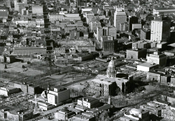 Aerial view of the Colorado State Capitol building, a park, 15th (Fifteenth) and 16th (Sixteenth) Streets, Broadway and Lincoln Street in the Central Business District of Denver. Colorado. Shows the Denver City and County Building annex, the Carnegie library building, the Voorhies Memorial, reflecting pool and fountains in Civic Center Park, First Presbyterian Church on Broadway, the State Medical Examiners Office, the State Museum, the Colorado State Bank, the Republic Building, the Denver Theater Building, the Conoco building and the Paramount Theater. Businesses line the streets, signs read: "Gump" "Walgreen Drugs" and "Used Cars." Bill boards and standing signs read: "Country Club Beer, Famous For Its Flavor" "Phillips 66 Runs Smoother" and "Burlington Route Zephyr." The excavation site for the Hilton Hotel is on Court Place. (John A. Myers/Denver Public Library/Western History Collection/(Denver Public Library/Western History Collection/Z-11640)
cityscape; capitol hill; civic center; historic; denver public library; dpl; archive; archival; denverite