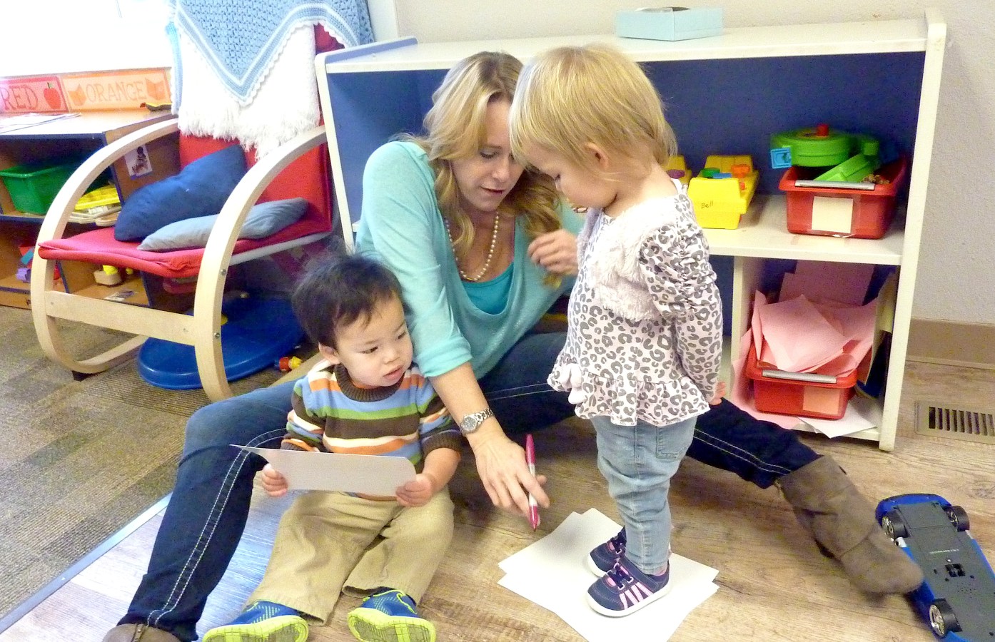 Jodi Bell, lead toddler teacher at Teaching Tree Early Childhood Learning Center in Loveland, outlines a child's foot. (Ann Schimke/Chalkbeat)