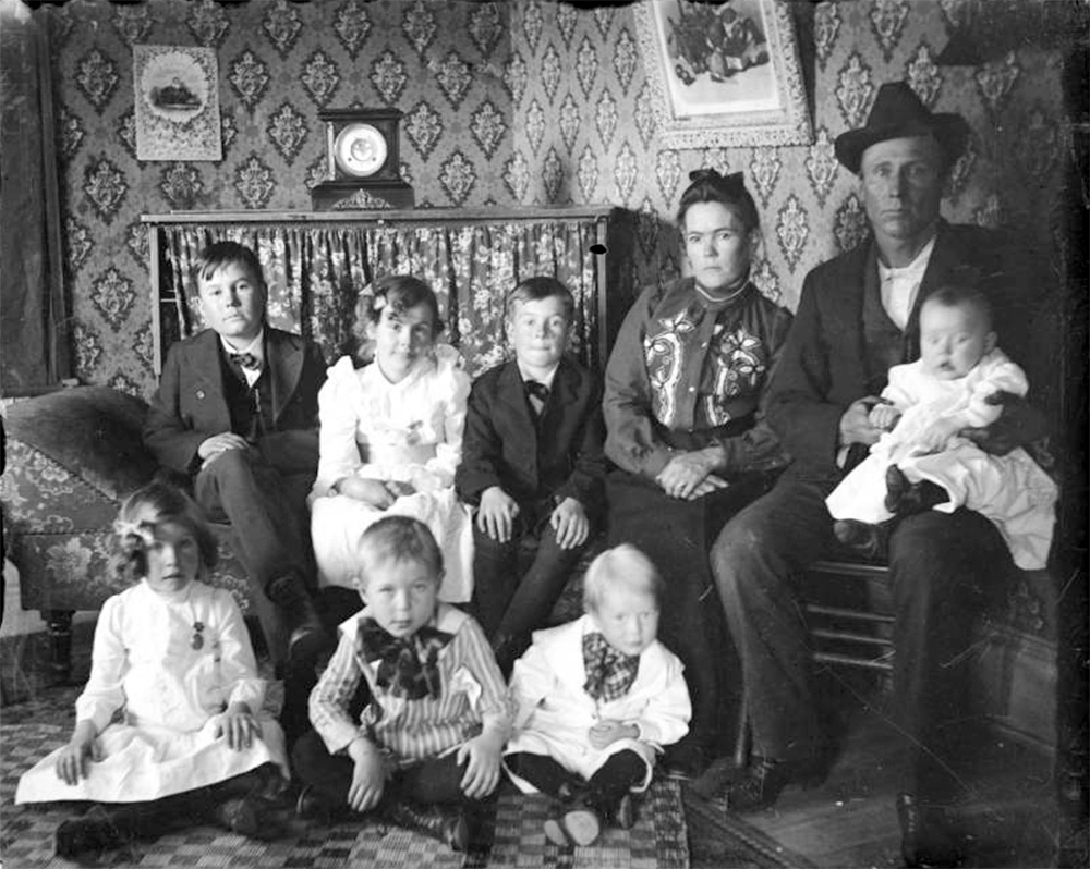 Group portrait of a man, woman, boys, girls, and baby, in Denver, Colorado; interior decor includes a mantle clock, costume includes applique. Between 1904 and 1915. (Charles Lillybridge/History Colorado/90.152.1125 DPLY)
history colorado; historic; denver public library; dpl; archive; archival; denverite