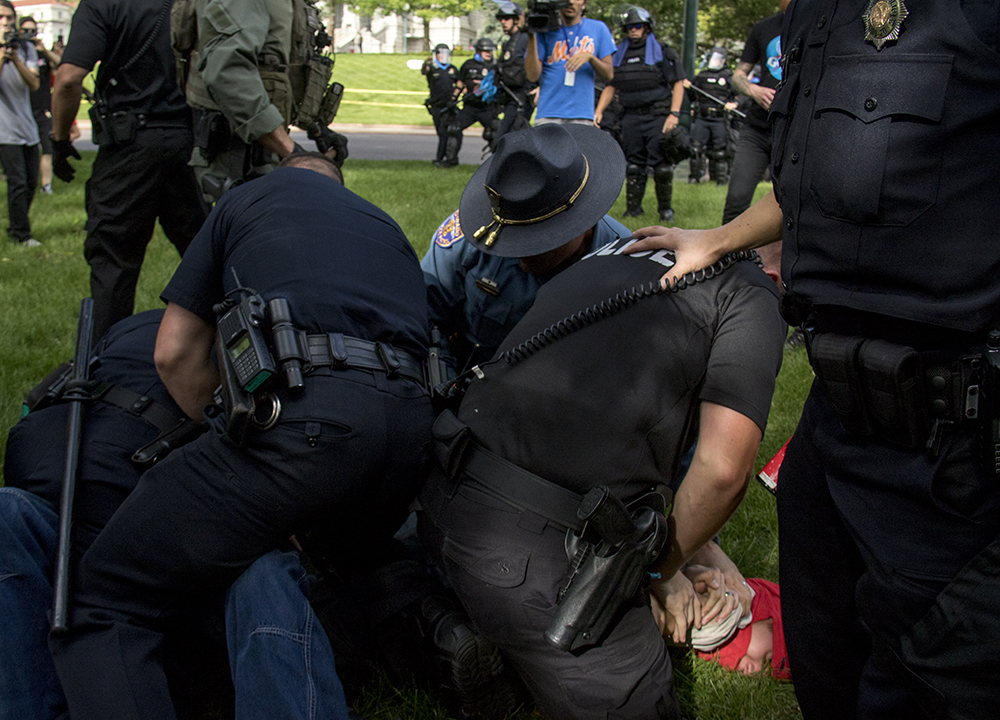 Two anarchist protesters are thrown to the ground and detained by police after they tried to start a fight with bikers leaving the park. A rally against Sharia law atop the Capitol steps, June 10, 2017. (Kevin J. Beaty/Denverite) copolitics; rally; protest; sharia law; islamophobia; kevinjbeaty; denver; colorado; denverite;