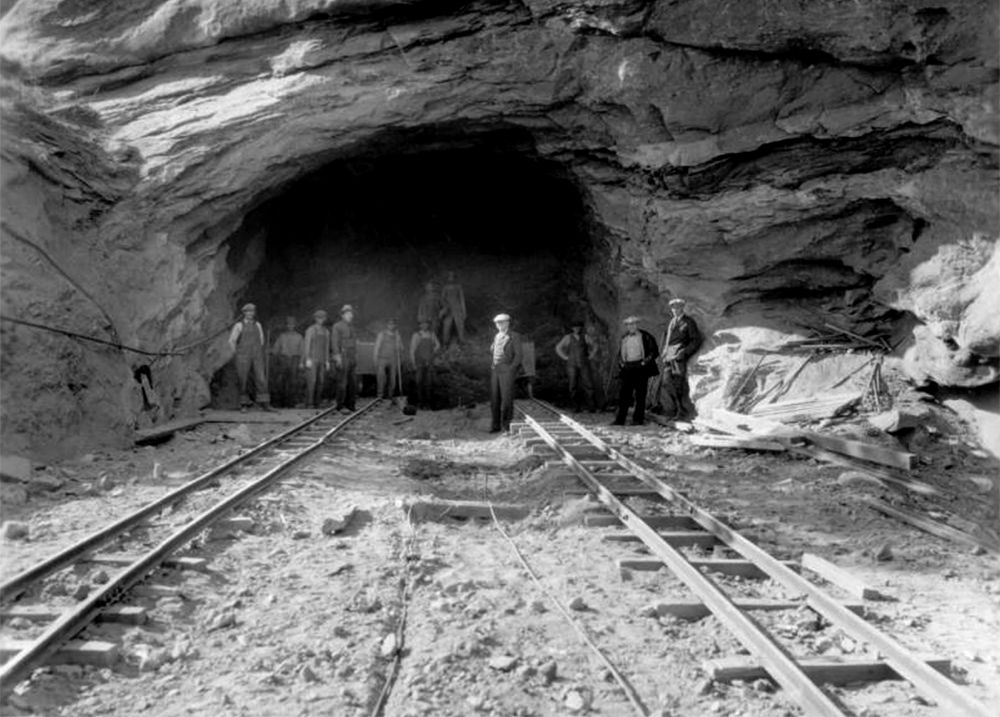 Laborers pose near ore cars and on stone rubble, in the entrance to a road tunnel under construction, in Red Rocks Park, a Denver Mountain Park near Morrison in Jefferson County, Colorado. (Denver Public Library/Western History Collection/Z-8888) red rocks; civilian conservation corps; archive; denver; colorado; kevinjbeaty;