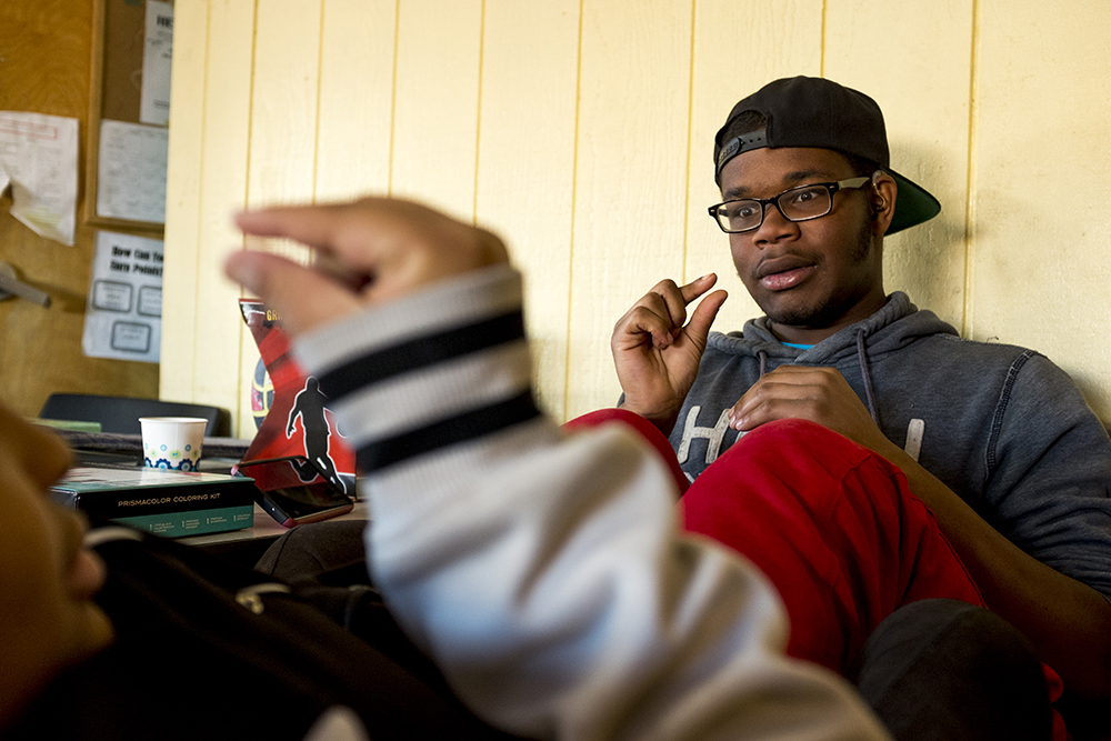Zee, 19, and her husband Chris S., 20, who are both deaf, sign to each other as they cuddle. Christmas Day at Urban Peak, a shelter for Denver's homeless youth, Dec. 25, 2017. (Kevin J. Beaty/Denverite)