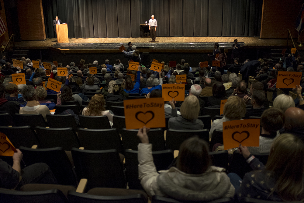 The crowd holds signs for a "clean DREAM act" as Mike Coffman speaks at a town hall event at Cherry Creek High School, Feb. 21, 2018. (Kevin J. Beaty/Denverite) copolitics; town hall; mike coffman; greenwood village; denver; colorado; denverite; kevinjbeaty;