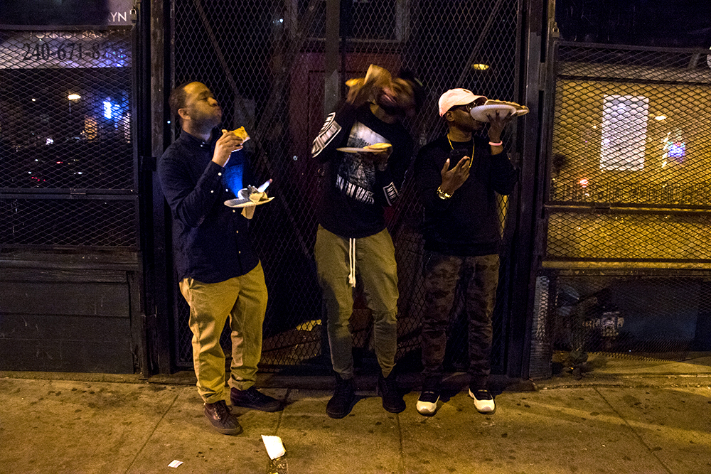 Tony Range (left to right), Tyrell Harvey and Maurice Brown munch on pizza after closing time in LoDo, March 12, 2018. (Kevin J. Beaty/Denverite)