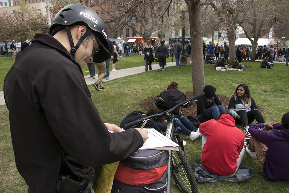 A Denver Police officer writes a public consumption ticket. Denver's 2018 Mile High 420 Festival, April 20, 2018. (Kevin J. Beaty/Denverite)
420; stoner; denver; denverite; colorado; kevinjbeaty;