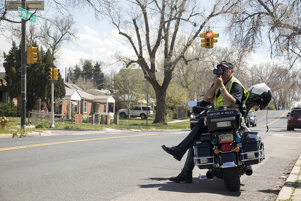 Officer George Gann enforces the speed limit in a school zone on Steele Street, April 23, 2018. (Kevin J. Beaty/Denverite)