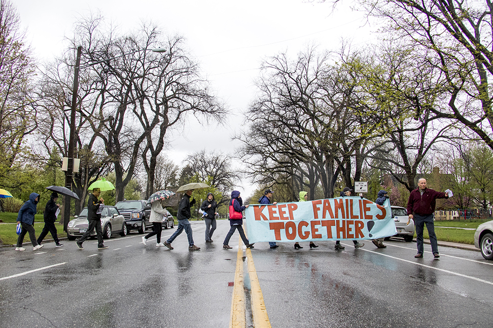 An interfaith coalition march across Montview Boulevard seven times for a “Jericho walk,” an Old Testament reference, in solidarity with immigrants living in sanctuary across the country to avoid deportation. Araceli Velasquez has lived on this block inside Park Hill United Methodist Church and Temple Micah for nine months. Similar protests took place on Thursday in 11 other U.S. cities. May 3, 2018. (Kevin J. Beaty/Denverite)