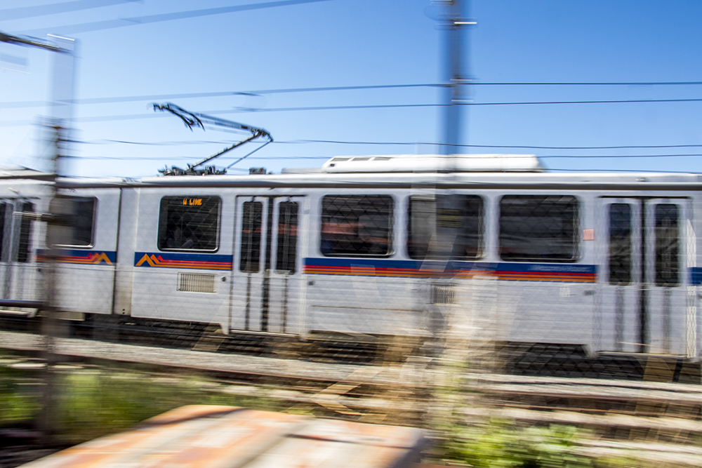 An RTD train whizzes by Strange Craft Beer Company's patio, May 16, 2018. (Kevin J. Beaty/Denverite)