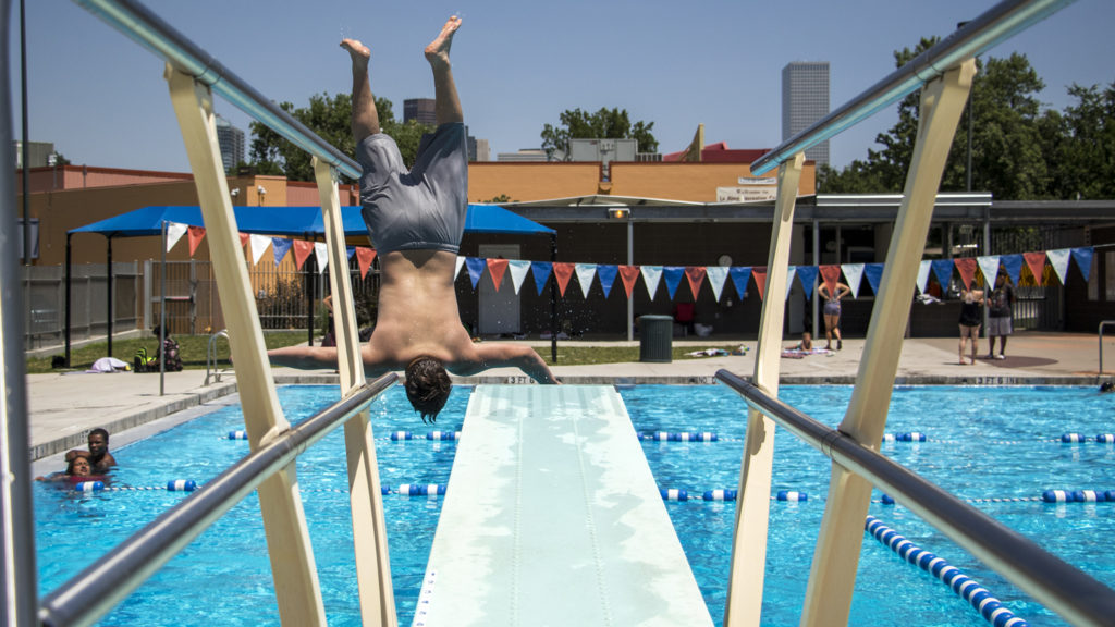 Ely, 12, flips into the pool at the La Alma Recreation Center, July 11, 2018. (Kevin J. Beaty/Denverite)
