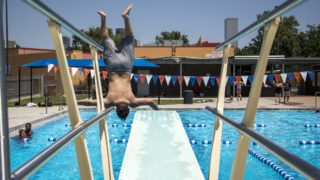 Ely, 12, flips into the pool at the La Alma Recreation Center, July 11, 2018. (Kevin J. Beaty/Denverite)