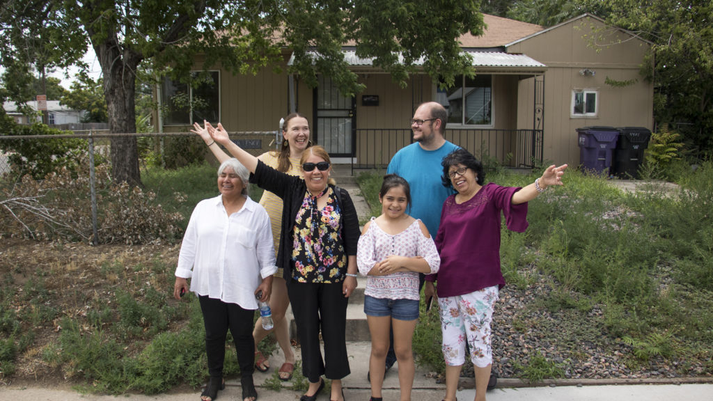 Members of the GES Coalition Organizing for Health and Housing Justice Angelina Torres (left to right), Nola Miguel, Mercedes Gonzalez and her granddaughter Rachel, Robin Reichhardt and Maria De Luna Jimenez pose for a photo in front of a property they acquired in Elyria Swansea, July 26, 2018. (Kevin J. Beaty/Denverite)