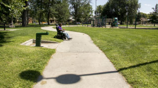 John Abeyta crosses the sidewalk at Russell Square Park in Denver's Cole neighborhood, Aug. 9, 2018. (Kevin J. Beaty/Denverite)
