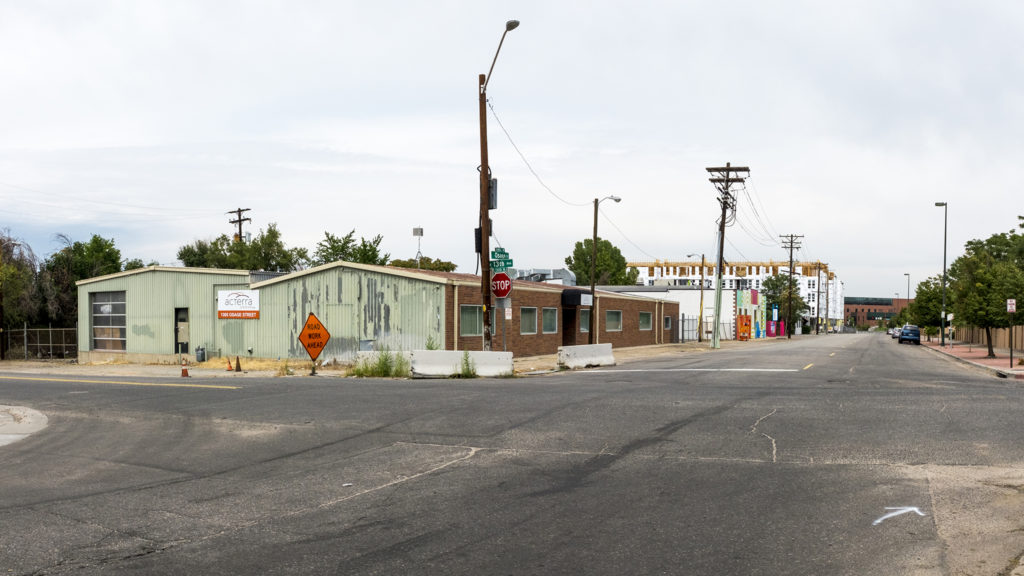 A vacant part of a lot that developers Opus Group are considering for an apartment building (left) and the Wellington Apartments on Osage Street south of Colfax Avenue, Sept. 3, 2018. (Kevin J. Beaty/Denverite)