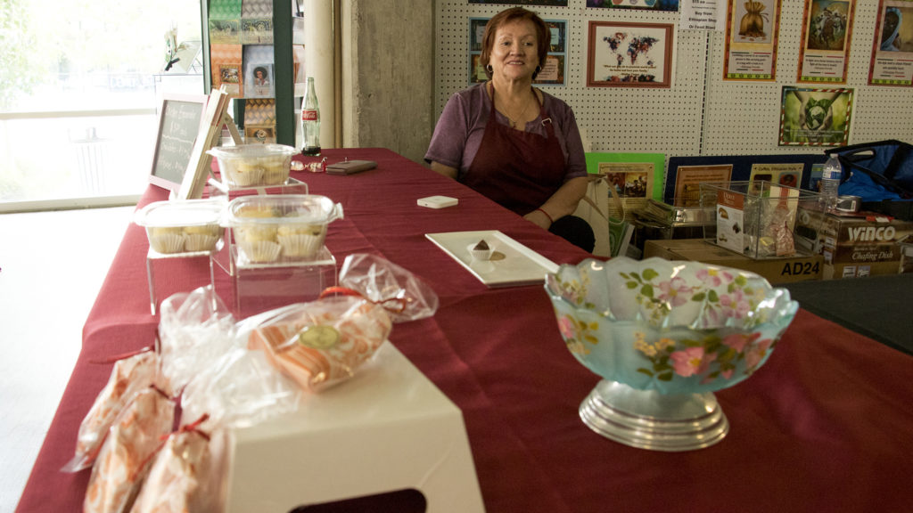 Cornelia Gamboa poses for a portrait behind her empanada and candy table at Food Bridge Marketplace, Sept. 20, 2018. (Kevin J. Beaty/Denverite)