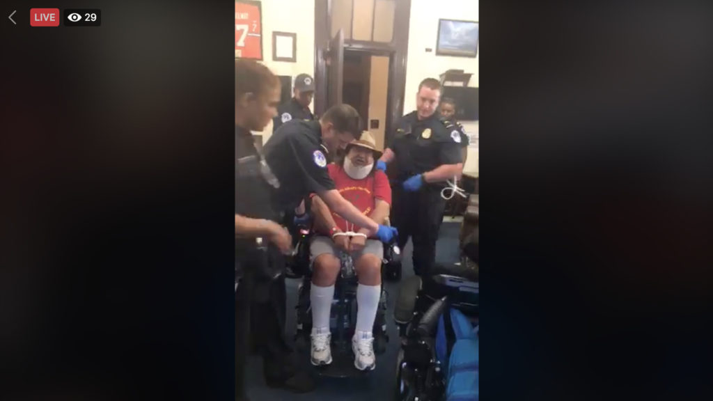 A protester is arrested for occupying Sen. Cory Gardner's office in Washington, D.C. Sept. 20, 2018. (Hope Russell Moseley's live Facebook stream)