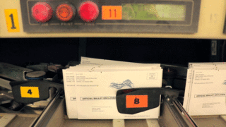 Ballots are sorted for mailing in a massive machine inside the U.S. Postal Service's sorting and shipping facility in Stapleton, Oct. 16, 2018.
