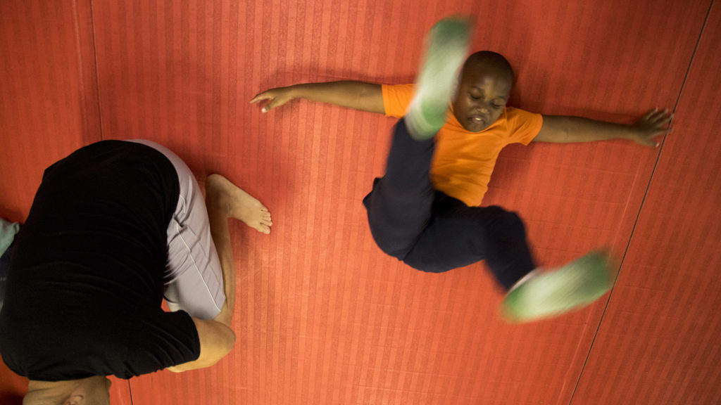 Skiler (7) learns how to fall safely during boxing class at Heavy Hearts Heavy Hands gym in Aurora, Oct. 17, 2018. (Kevin J. Beaty/Denverite)