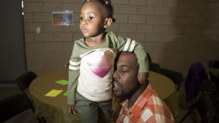 Regis Ware embraces his daughter, Brailyn (5) during A Father Daughter Occasion at the Dahlia Campus for Health and Well-Being in Northeast Park Hill, Oct. 27, 2018. (Kevin J. Beaty/Denverite)
