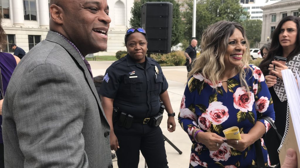 Mayor Michael Hancock next to Cecelia Dunn (far right), a domestic violence survivor, following a presentation marking the start of Domestic Violence Awareness month on Monday, Oct. 1, 2018, in Denver. (Esteban L. Hernandez/Denverite)