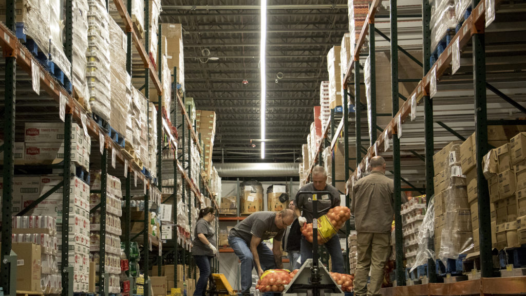 Volunteers load onions for distribution at Food Bank of the Rockies' warehouse in Aurora, Nov. 13, 2018. (Kevin J. Beaty/Denverite)