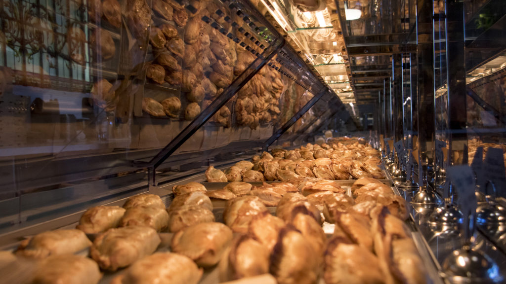 A long row of hot empanadas in Maria Empanada's new location on Platte Street, Dec. 18, 2018. (Kevin J. Beaty/Denverite)