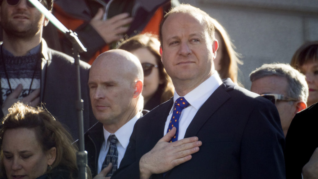 Jared Polis holds his hand over his heart during the National Anthem before he is inaugurated as Colorado's 43rd governor, Jan. 8, 2018. (Kevin J. Beaty/Denverite)