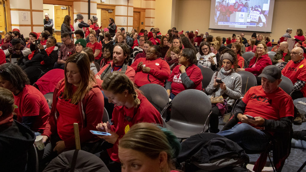 Denver teachers cheer as a live feed of a rally outside the Denver Public Library is fed inside to a negotiation room, Feb. 12, 2019. (Kevin J. Beaty/Denverite)