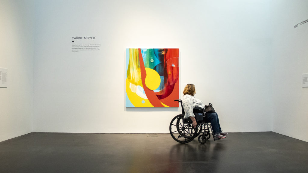 Corinne Hobbs inspects art in a Georgia O'Keefe exhibit at the Museum of Contemporary Art, Feb. 15, 2019. (Kevin J. Beaty/Denverite)
