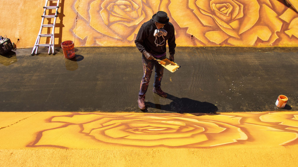 Thomas Evans, AKA Detour, paints a mural in a drainage channel running through Montbello, May 11, 2019. (Kevin J. Beaty/Denverite)