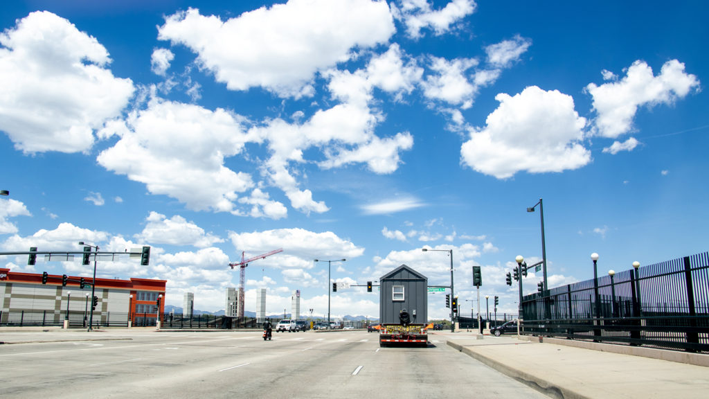 Tiny homes from the Beloved Community Village's second home in Five Points cruise through Denver on their way to Globeville, May 13, 2019. (Kevin J. Beaty/Denverite)