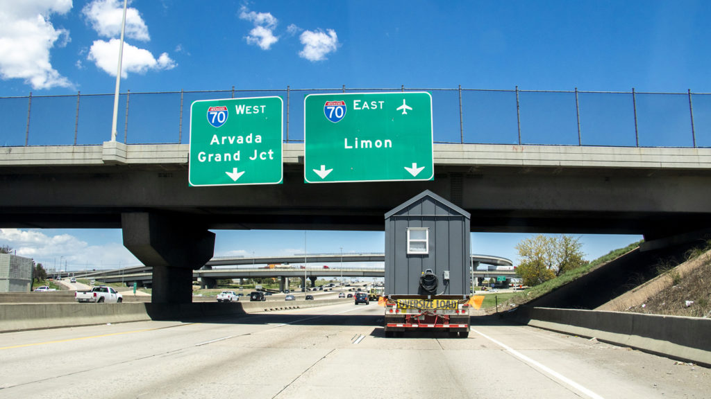 Tiny homes from the Beloved Community Village's second home in Five Points cruise through Denver on their way to Globeville, May 13, 2019. (Kevin J. Beaty/Denverite)