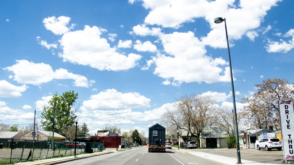 Tiny homes from the Beloved Community Village's second home in Five Points are carried through Globeville, May 13, 2019. (Kevin J. Beaty/Denverite)