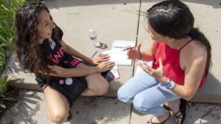 Candi CdeBaca teaches first-time voter MaLinda Medina how to cast a ballot as she canvasses in Five Points on election day, June 4, 2019.