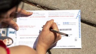 First-time voter MaLinda Medina fills out her ballot outside of her home in Five Points, June 4, 2019. (Kevin J. Beaty/Denverite)