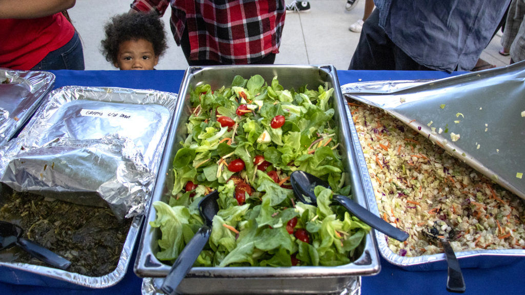 Guests line up to fill plates at the Dahlia Campus for Health and Well-Being's annual fish fry, June 19, 2019. (Kevin J. Beaty/Denverite)
