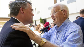 Don Schierling, a member of Brothers Redevelopment Inc.'s board, embraces Sen. Cory Gardner, thanking him for helping to secure federal dollars for the company's affordable housing project in Aurora. July 12, 2019. (Kevin J. Beaty/Denverite)