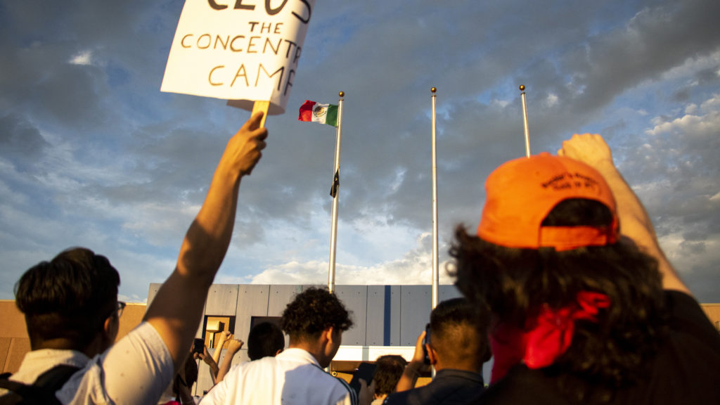 A Mexican flag replaced a Colorado state flag aboce Aurora's private immigration detention facility during a massive protest, June 14, 2019. (Kevin J. Beaty/Denverite)