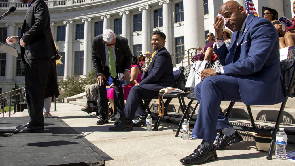 Mayor Michael Hancock wipes his forehead on a hot inauguration day on the City and County Building steps, July 15, 2019. (Kevin J. Beaty/Denverite)