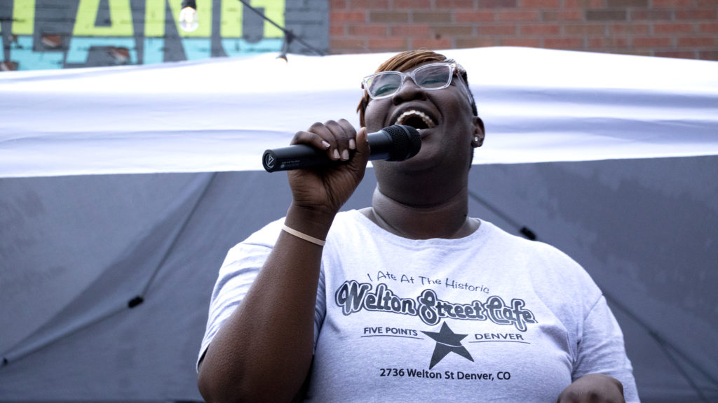 Fathima Dickerson speaks during Welton Street Cafe's anniversary celebration. Five Points, July 30, 2019. (Kevin J. Beaty/Denverite)