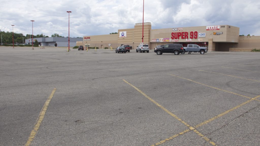 A mostly empty parking lot at the Super 99 Cents store on South Sheridan Boulevard on Monday, July 8, 2019, in Denver. (Esteban L. Hernandez/Denverite)