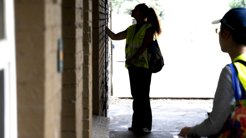 Kristen Gines knocks on a Lakewood motel door during a count of the unhoused in Jefferson County, Aug. 21, 2019. (Kevin J. Beaty/Denverite)