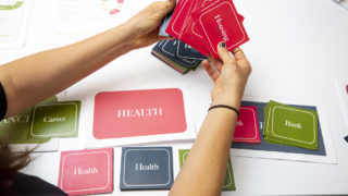 Radian's Dee Dee DeVuyst explains The Game of Life: Redline Edition, which she created. Sept. 24, 2019. (Kevin J. Beaty/Denverite)