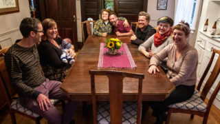Stephen Polk (left to right), Sarah Wells and baby Charlie Wells-Polk, Sara Baumann, Paul Bindel, Josiah Hesse, Samantha Hinshaw and Meredith Turk sit around the table in Capitol Hill, Oct. 1, 2019. (Kevin J. Beaty/Denverite)