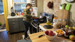 Sara Baumann cooks inside her shared home at 901 N. Clarkson St. Oct. 1, 2019. (Kevin J. Beaty/Denverite)