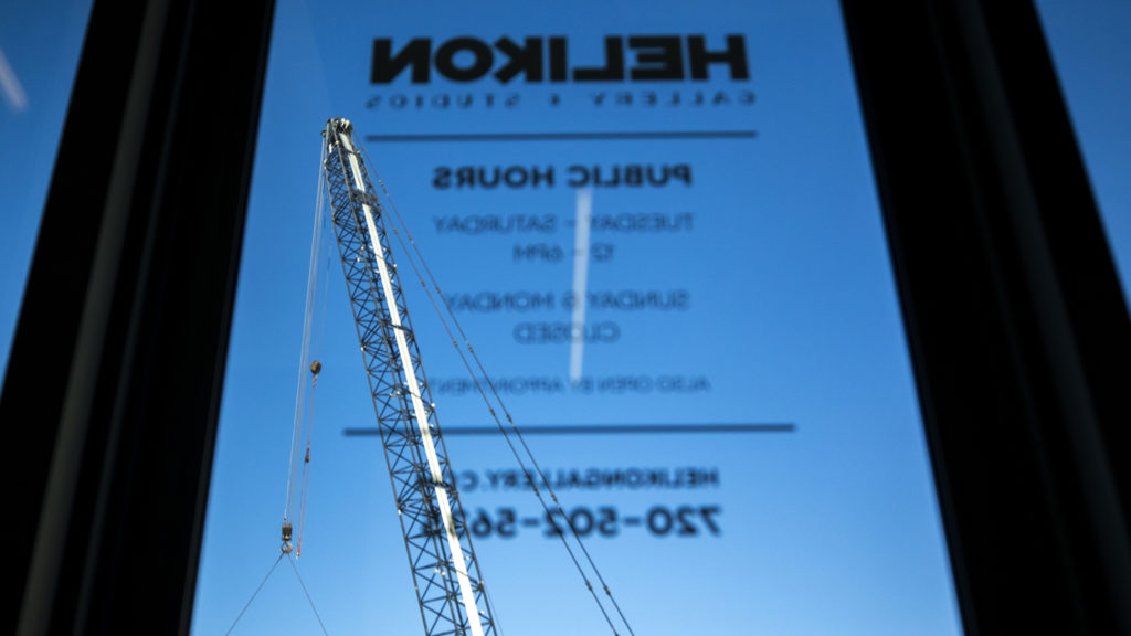 Construction seen through windows at Helikon Gallery and Studios on Wynkoop Street. Five Points, Oct. 2, 2019. (Kevin J. Beaty/Denverite)