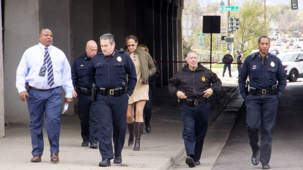 Denver police officials walk a crime scene where a man was fatally shot by an officer on Monday, Oct. 21, in the Lincoln Park neighborhood. (Esteban L. Hernandez/Denverite)