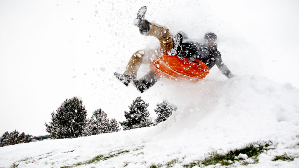 Cruz Ortega and Aryel Ramos fly over a jump at Ruby Hill Park on small sled on a snow day, Oct. 29, 2019. (Kevin J. Beaty/Denverite)