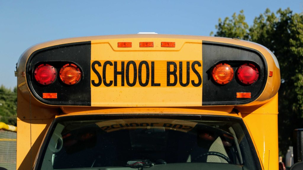 A school bus sits outside Alameda International Senior/Junior High School in Lakewood. (Kevin J. Beaty/Denverite)